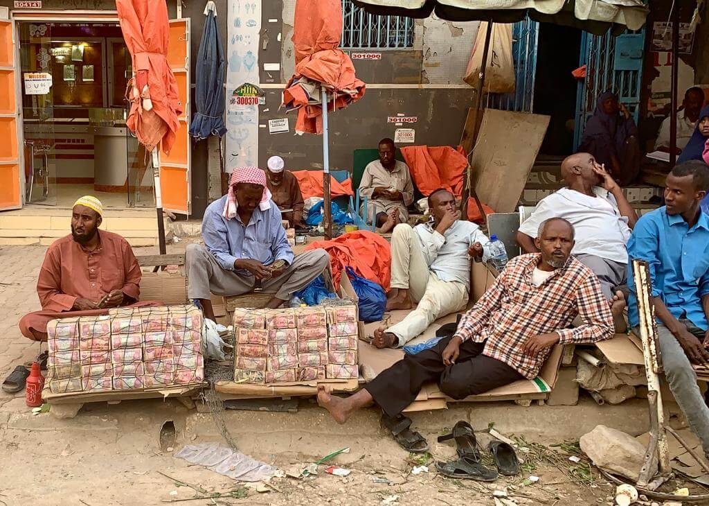 noelle wonders Men sitting by stacks of money in the streets of Hargeisa Somaliland